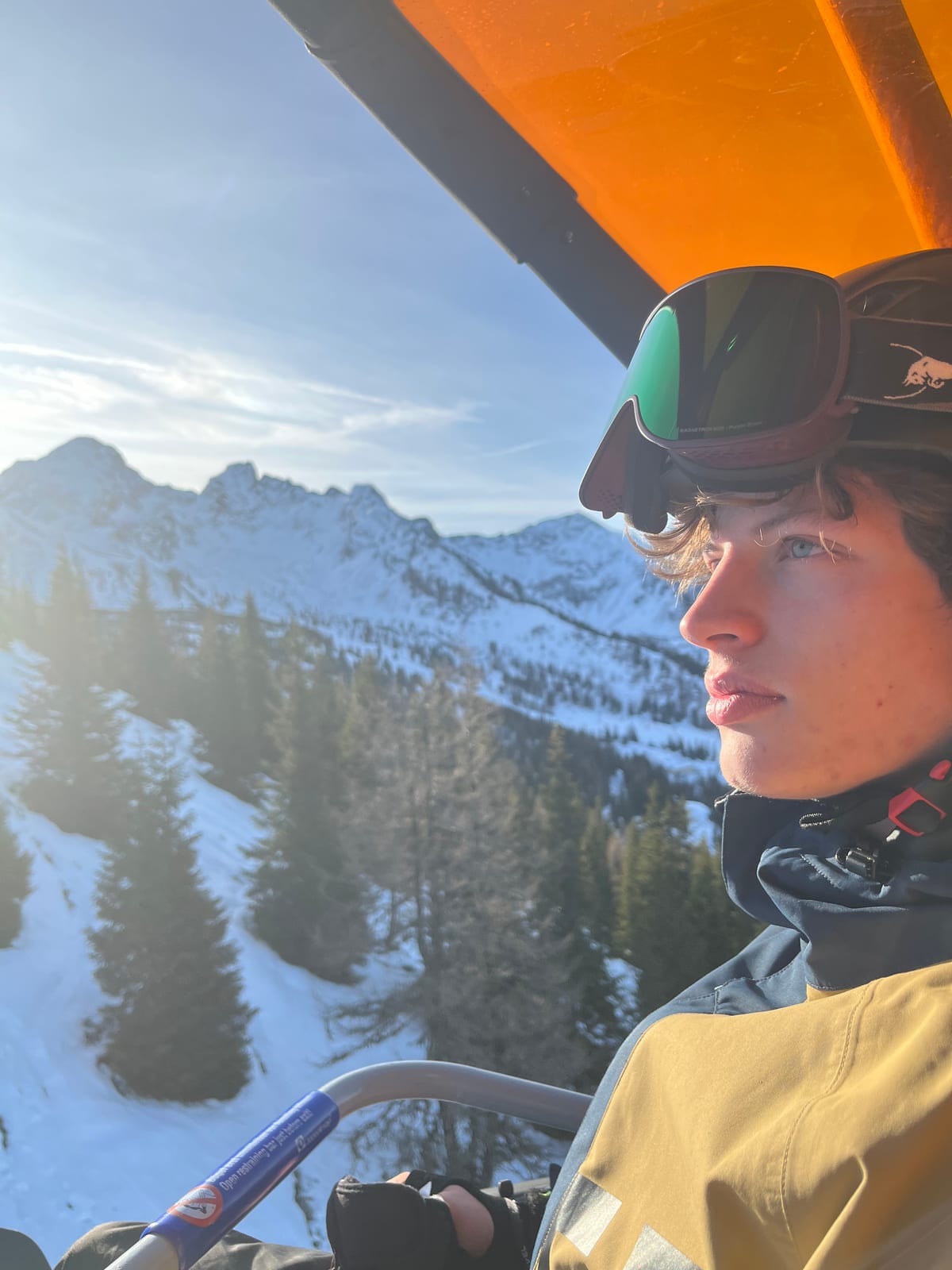 Walking green flag Richard Kocanda on a ski lift in snowy mountains